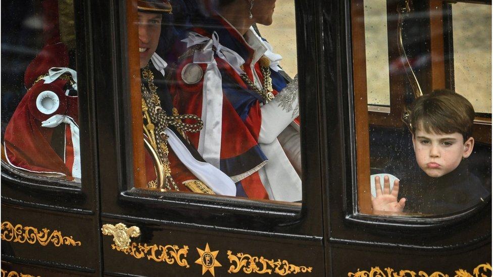 Prince William, Prince of Wales, Britain's Catherine, Princess of Wales and Britain's Prince Louis of Wales travel back to Buckingham Palace from Westminster Abbey in central London 