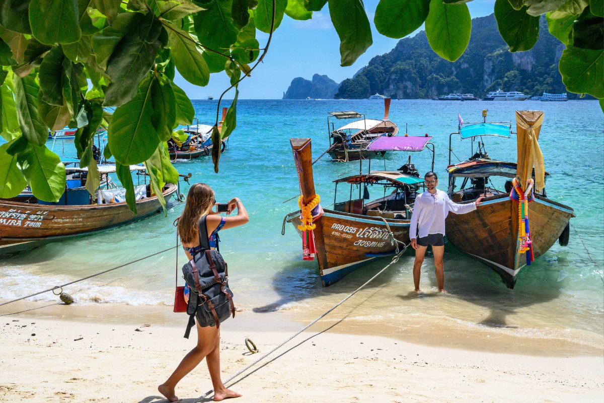 นักท่องเที่ยวต่างชาติถ่ายภาพกับเรือหางยาว